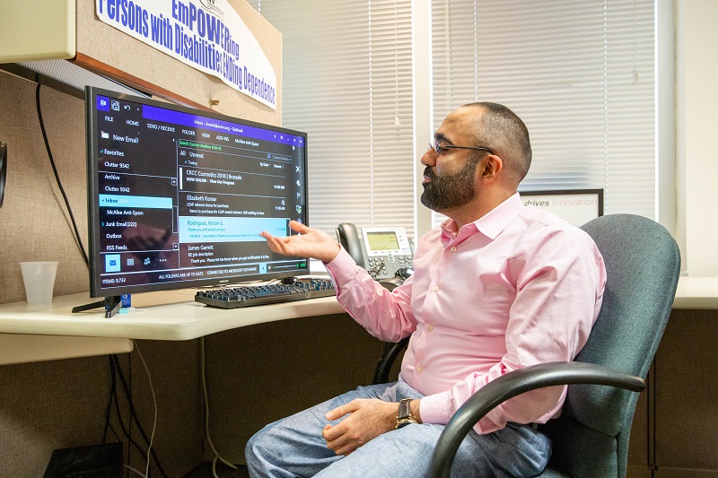 Amir in front of a computer running a screen magnifier