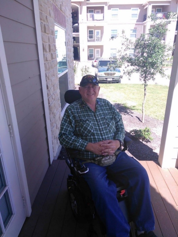 Photo of Mark outside with his wheelchair