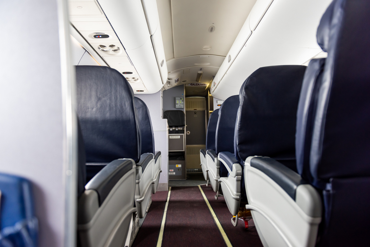 View down airplane aisle with empty seats on either side