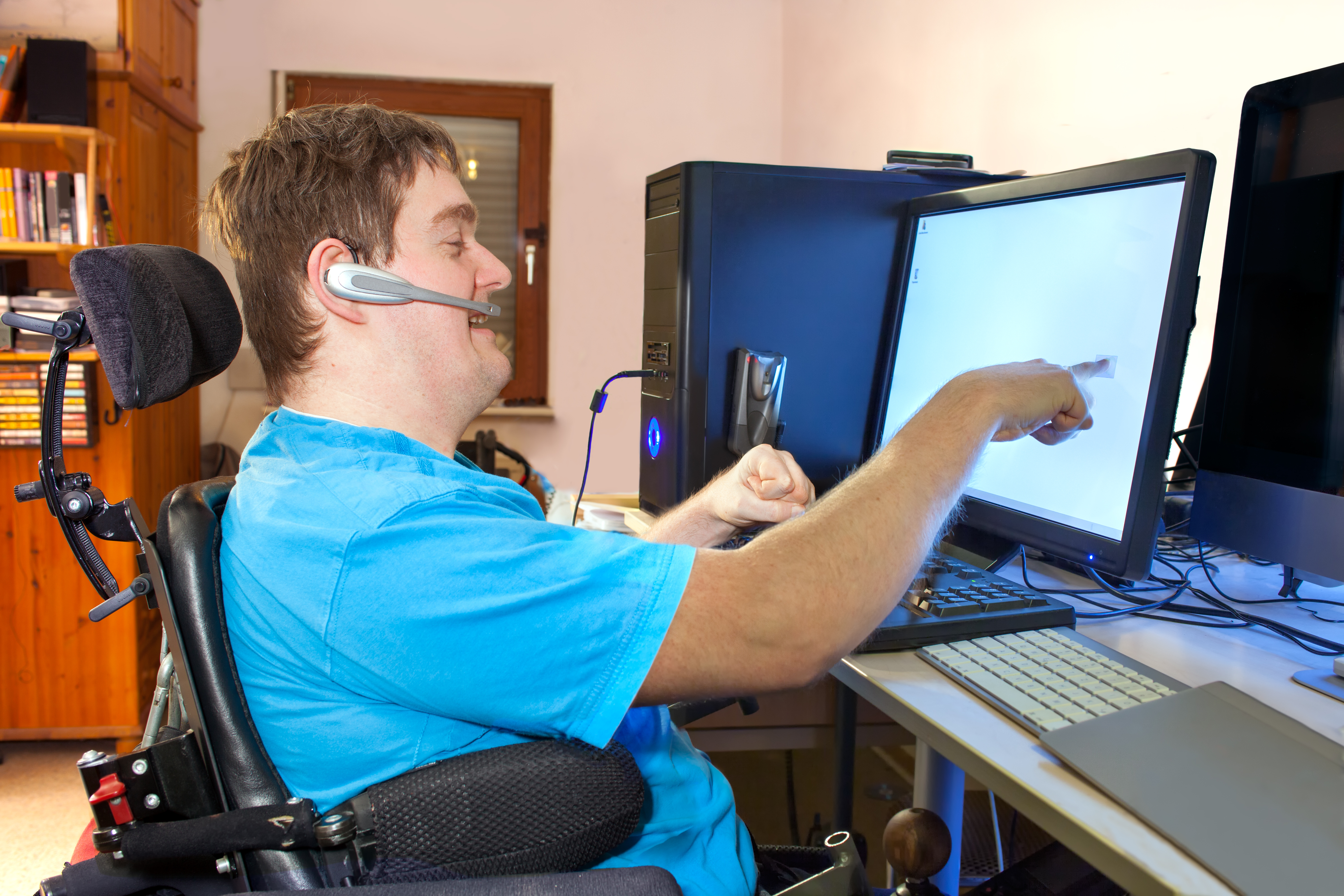 Man using wheelchair using assistive technology at work
